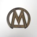 Elegant metal "M Automiesse" grille emblem for truck, circa 1950