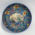 Plat creux en émaux polychromes de Longwy représentant héron et fleurs