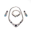Parure argentée Dior avec pierres bleues : collier, bracelet et boucles d'oreilles