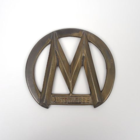 Élégant emblème de calandre "M Automiesse" en métal pour camion, circa 1950