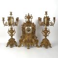 Regency-style gilded brass mantelpiece, clock, and candelabras